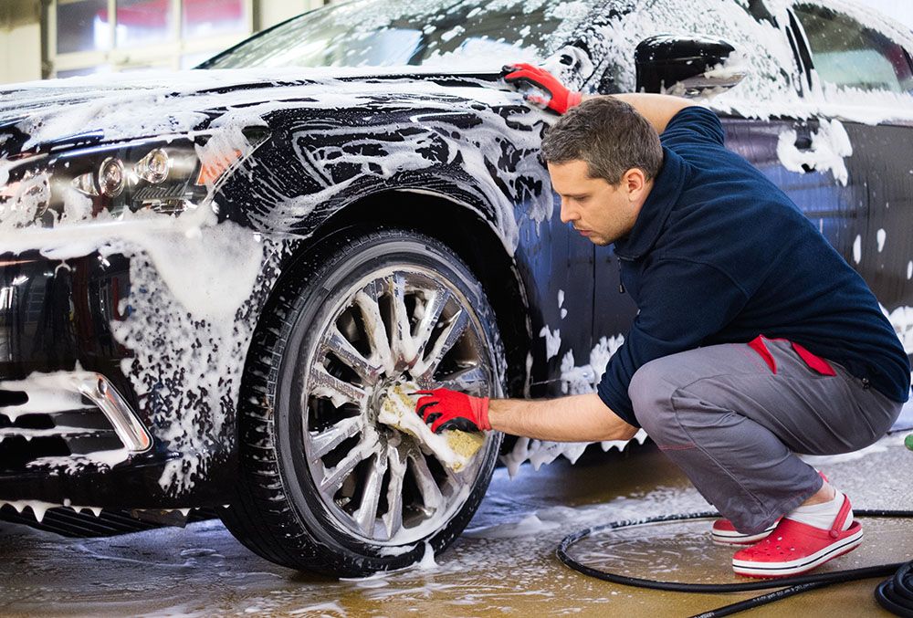 a man cleaning wheels before powder coating